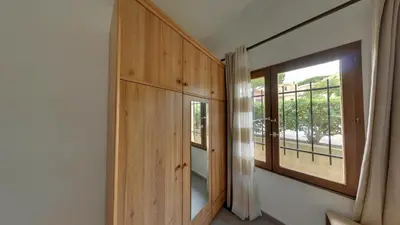 a room with a large window and a wooden cabinet at Gruissan: Maisonnette T2 avec jardin in Gruissan