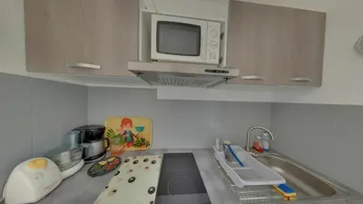 a small kitchen with a sink and a microwave at Gruissan: Maisonnette T2 avec jardin in Gruissan
