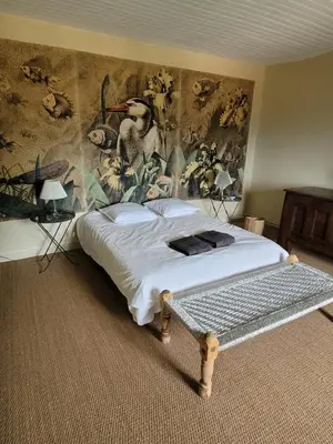 a bedroom with a bed with a painting on the wall at Maison familiale de charme in Chalabre