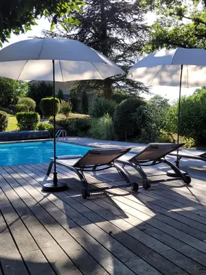 two chairs and two umbrellas next to a pool at Maison familiale de charme in Chalabre