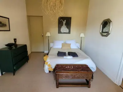 a bedroom with a large white bed and a green dresser at Maison familiale de charme in Chalabre