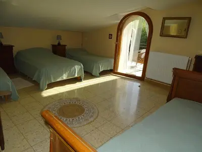 a bedroom with two beds and an open window at La Métairie de Lamourade, gîte nature in Saint-Ferriol