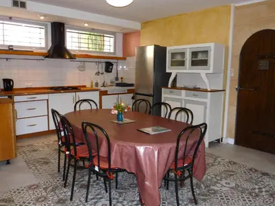 a kitchen with a table with chairs and a refrigerator at La Métairie de Lamourade, gîte nature in Saint-Ferriol