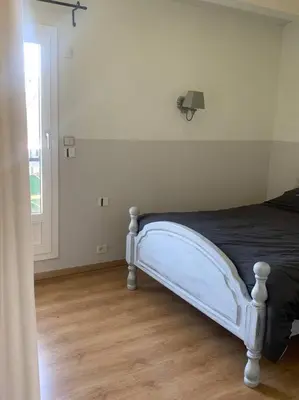a white bed in a room with a window at Appartement mirepoix in Mirepoix