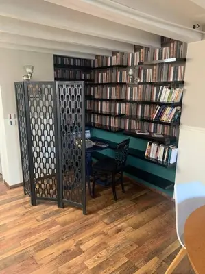 a library with a table and a bunch of books at Appartement mirepoix in Mirepoix