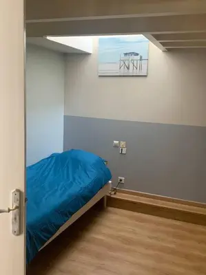 a room with a bed with a blue blanket in it at Appartement mirepoix in Mirepoix