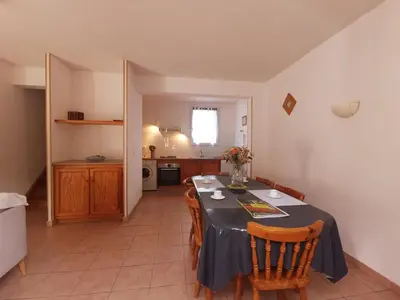 a dining room with a table and chairs and a kitchen at La trillano in Trilla