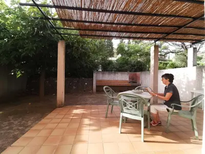 a woman sitting at a table under a pergola at La trillano in Trilla