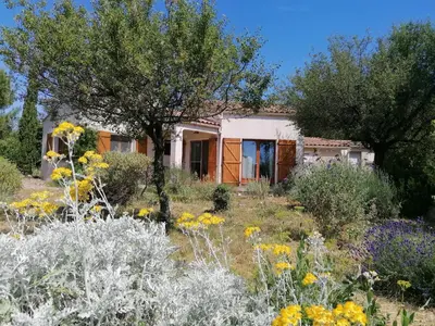 a house in the middle of a garden with flowers at Gîte Les Romarins Vue exceptionnelle ! in Saint-Jean-de-Minervois