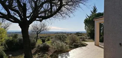 a view of a garden with a tree and a building at Gîte Les Romarins Vue exceptionnelle ! in Saint-Jean-de-Minervois