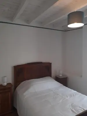 a bedroom with a white bed and two night stands at la maison des vendangeurs in Villesequelande