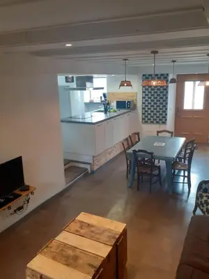 a kitchen and living room with a table and a kitchen and a dining room at la maison des vendangeurs in Villesequelande