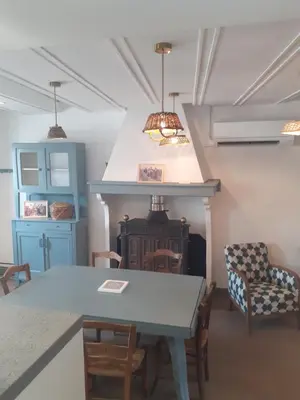 a dining room with a table and a fireplace at la maison des vendangeurs in Villesequelande