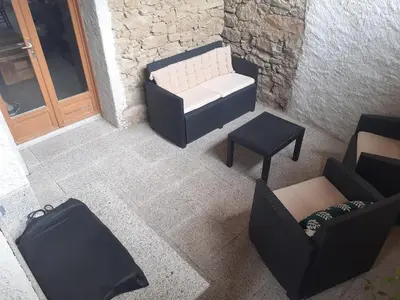 a room with a bench and a table and chairs at la maison des vendangeurs in Villesequelande