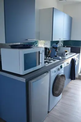 a kitchen with a washing machine and a microwave at Gîte Marin in Narbonne