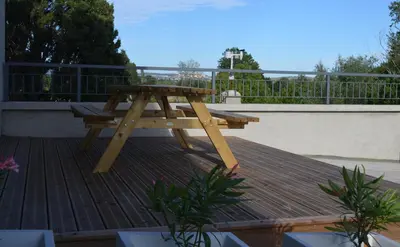 a wooden picnic table sitting on top of a deck at Gîte Marin in Narbonne