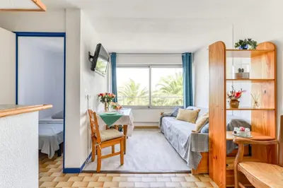 a living room with a couch and a table at Studio cabine Viktoria in Gruissan