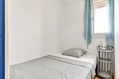 a small bedroom with a bed and a window at Studio cabine Viktoria in Gruissan