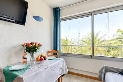 a table with a vase of fruit on it with a window at Studio cabine Viktoria in Gruissan