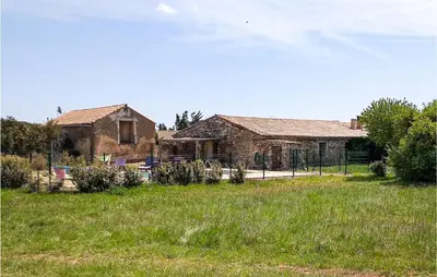an old stone house in a field of grass at Awesome Home In Pardailhan With Kitchen in Pardailhan