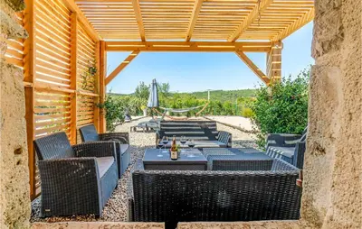 a patio with chairs and a table and a umbrella at Awesome Home In Pardailhan With Kitchen in Pardailhan
