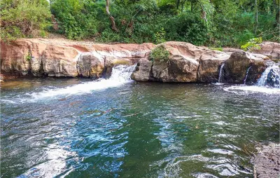 a waterfall in a pool of water in a river at Awesome Home In Pardailhan With Kitchen in Pardailhan