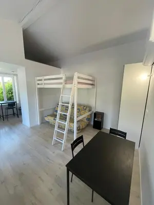 a room with a table and a room with bunk beds at Castres maisonnette proche du centre ville, parking et jardin in Castres