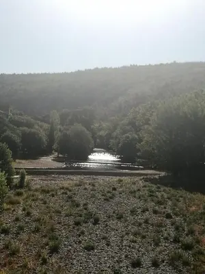 a river in the middle of a field with trees at EVANA in Bize-Minervois