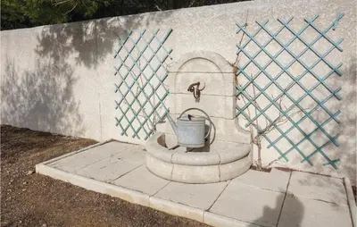 a bucket on a concrete wall with a fountain at Stunning Home In Ferrals Les Corbières in Ferrals-lès-Corbières