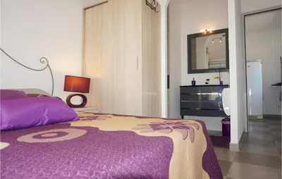 a bedroom with a purple bed and a dresser at Stunning Home In Ferrals Les Corbières in Ferrals-lès-Corbières
