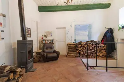a living room with a wood stove and a chair at Chez Shona in Lagrasse