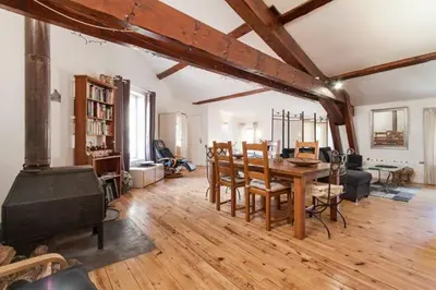 a large living room with a table and a fireplace at Chez Shona in Lagrasse