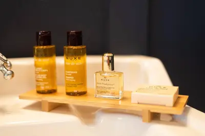 three bottles of soap on a wooden tray on a bathroom sink at La Maison de La Tour Pinte in Carcassonne