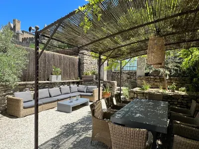 a patio with a pergola and a table and chairs at La Maison de La Tour Pinte in Carcassonne