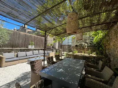 a patio with a table and chairs under a pergola at La Maison de La Tour Pinte in Carcassonne