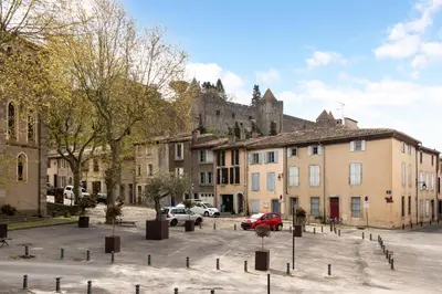 a street with buildings and a castle in the background at Les Gîtes de Laure - L'Or Blanc, Appartement avec Vue sur le Chateau, Climatisation, Netflix, à 160 m de la Cité Médiévale in Carcassonne