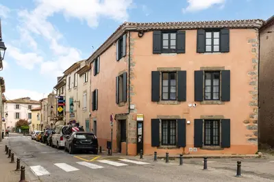 a building on a street with cars parked on the street at Les Gîtes de Laure - L'Or Blanc, Appartement avec Vue sur le Chateau, Climatisation, Netflix, à 160 m de la Cité Médiévale in Carcassonne