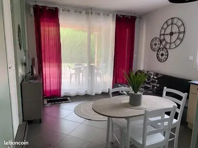 a table and chairs in a living room with red curtains at bienvenue chez nous in Badens
