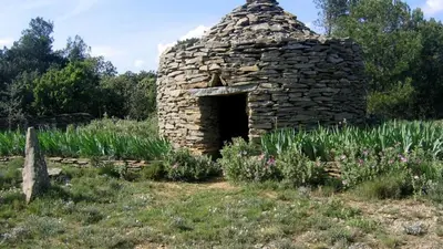 a stone fireplace in a field with flowers at bienvenue chez nous in Badens