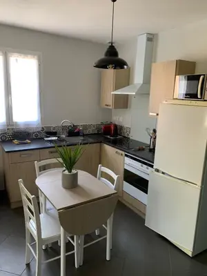 a kitchen with a table and a white refrigerator at bienvenue chez nous in Badens