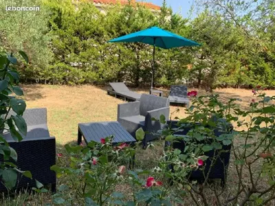 a patio with chairs and an umbrella in a yard at bienvenue chez nous in Badens