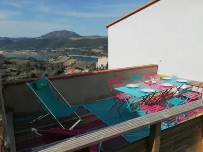 a table and chairs on a balcony with a view at Horizon Caramany : un havre de douceur, vue lac ! in Caramany