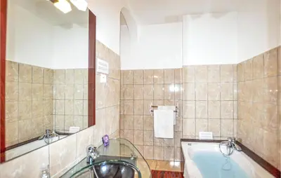 a bathroom with a bath tub and a sink at 2 Bedroom Gorgeous Home In Carcassonne in Carcassonne