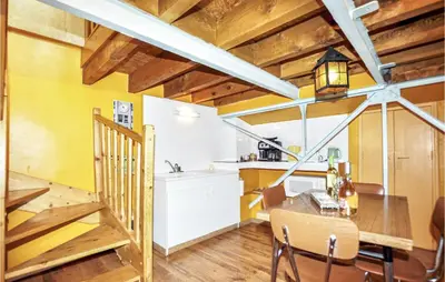 a kitchen and dining room with yellow walls and wooden ceilings at 2 Bedroom Gorgeous Home In Carcassonne in Carcassonne