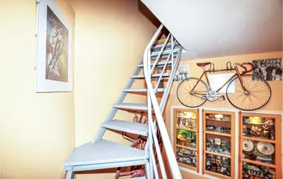 a staircase in a room with a bike on the wall at 2 Bedroom Gorgeous Home In Carcassonne in Carcassonne