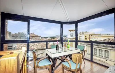 a dining room with a table and chairs and large windows at 2 Bedroom Gorgeous Home In Carcassonne in Carcassonne