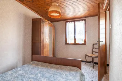 a bedroom with a bed and a window and a chair at Maison accueillante avec jardin à Albas in Albas