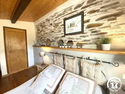 a bedroom with a stone wall and a bed with pillows at Dame nature in La Tourette-Cabardès