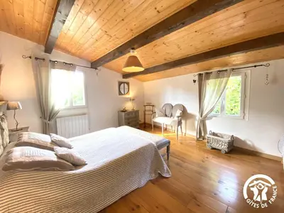 a bedroom with a large bed and wooden ceilings at Dame nature in La Tourette-Cabardès
