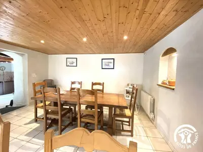 a dining room with a wooden table and chairs at Dame nature in La Tourette-Cabardès